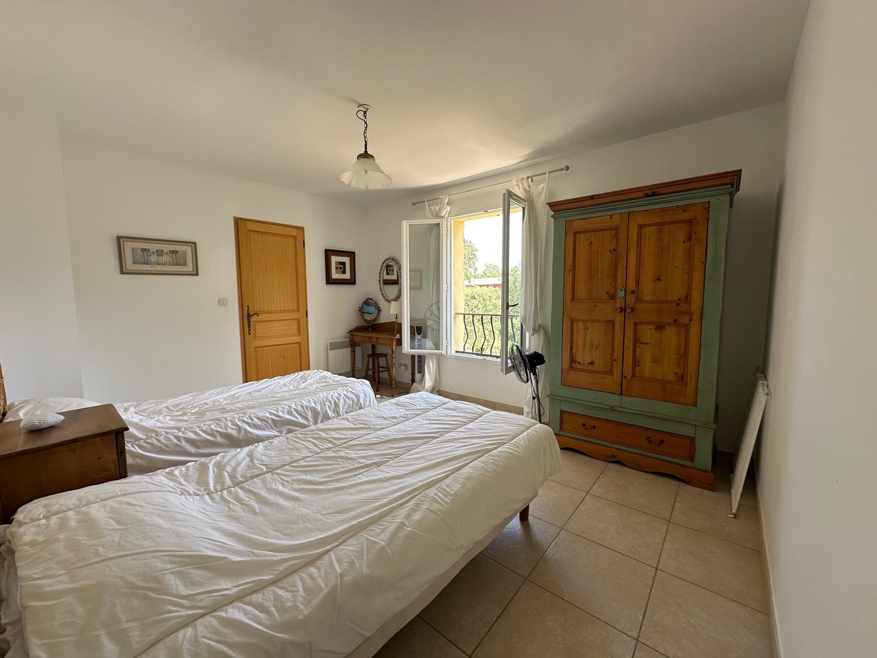 Chambre avec armoire ancienne et balcon